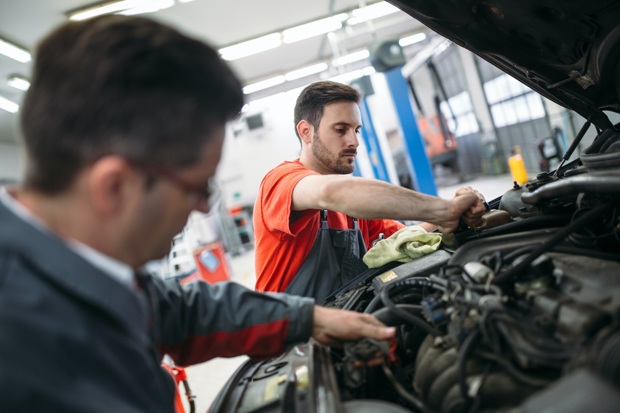 Profecional car mechanic changing motor oil at maintenance repair service station